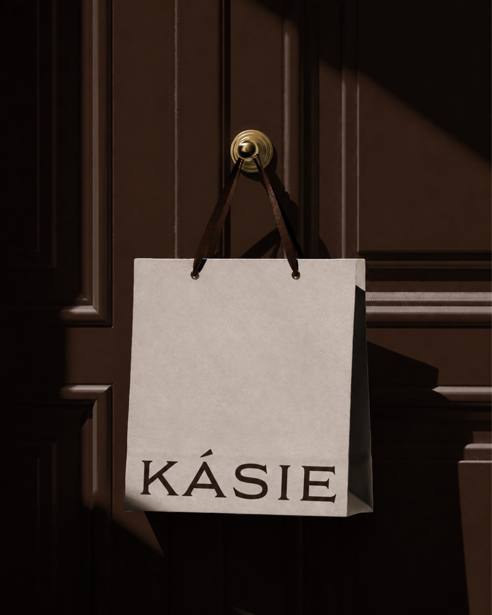 A KÁSIE shopping bag hanging on a wooden door
