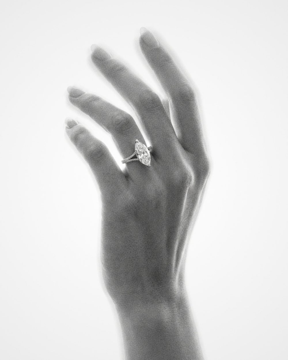 A hand wearing a diamond ring, black and white photograph