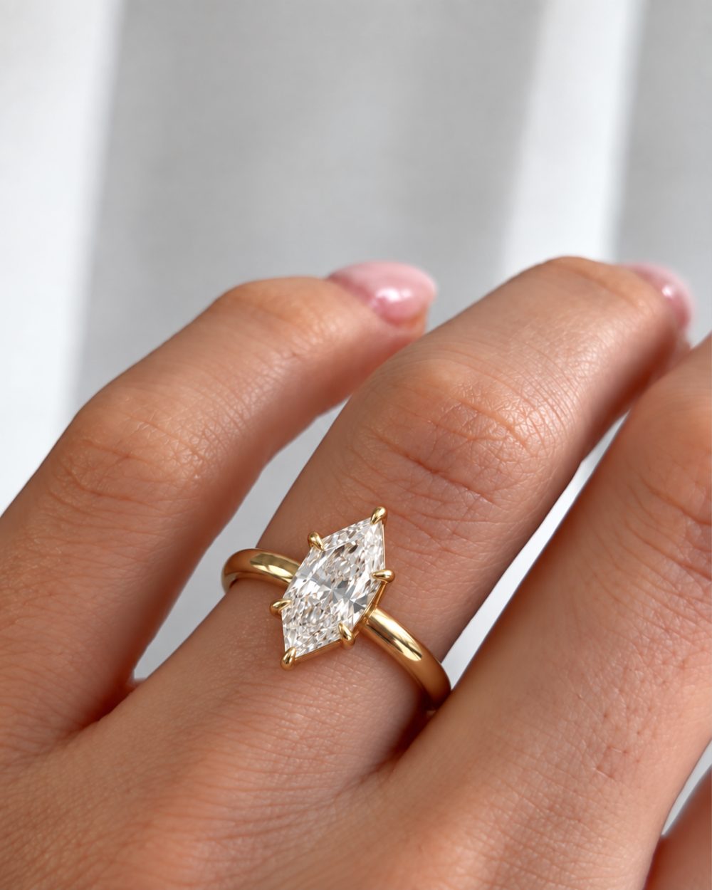 A hand wearing a marquise diamond ring