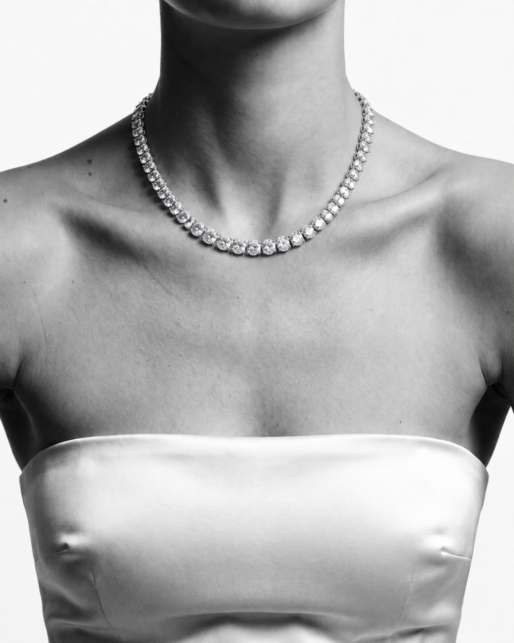 A model wearing a diamond necklace, black and white